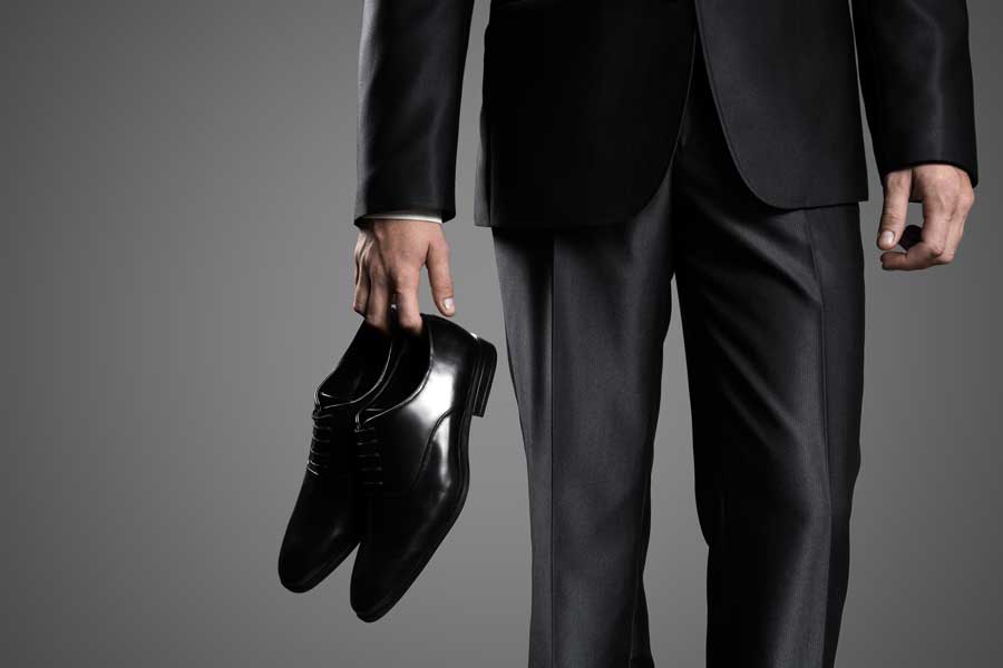 businessman holding dress shoes